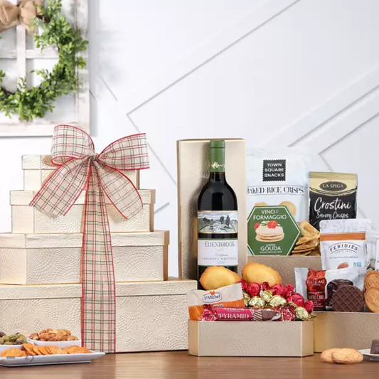 Gift basket with wine, cheese, and snacks on a wooden table.
