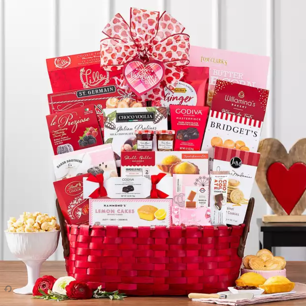 Gift basket with various products including chocolate and snacks on a wooden table.